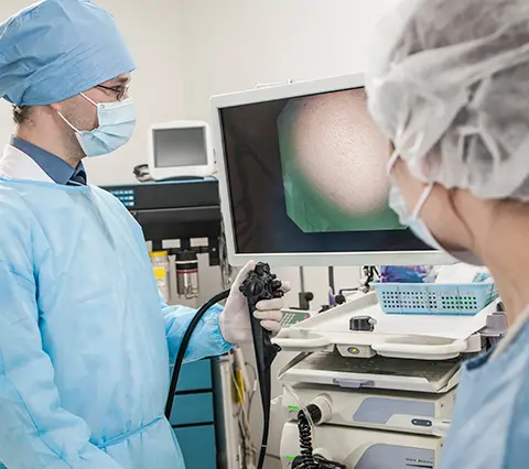 Gastroenterólogo en Bogotá realiza una cápsula endoscópica mientras observa imágenes del tracto digestivo