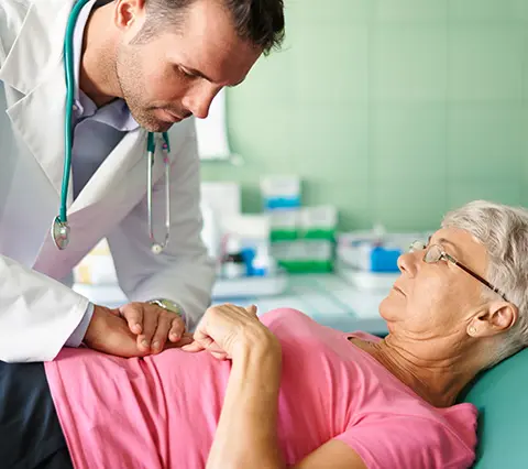 Médico del Centro de Gastroenterología Bogotá palpando el abdomen de una paciente recostada en camilla