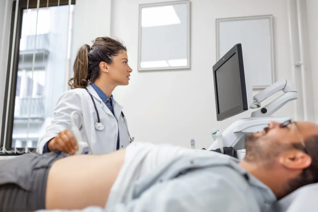 careful-female-doctor-white-coat-sitting-front-ultrasound-apparatus-conducting-abdominal-diagnostics-with-transducer